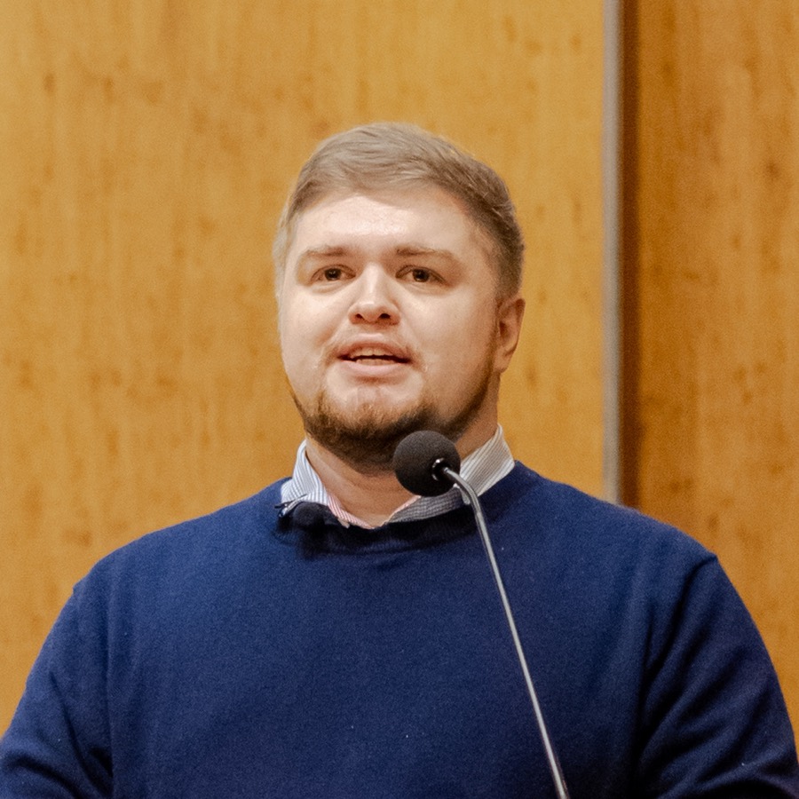 Portrait of Stephen Colón speaking at a podium